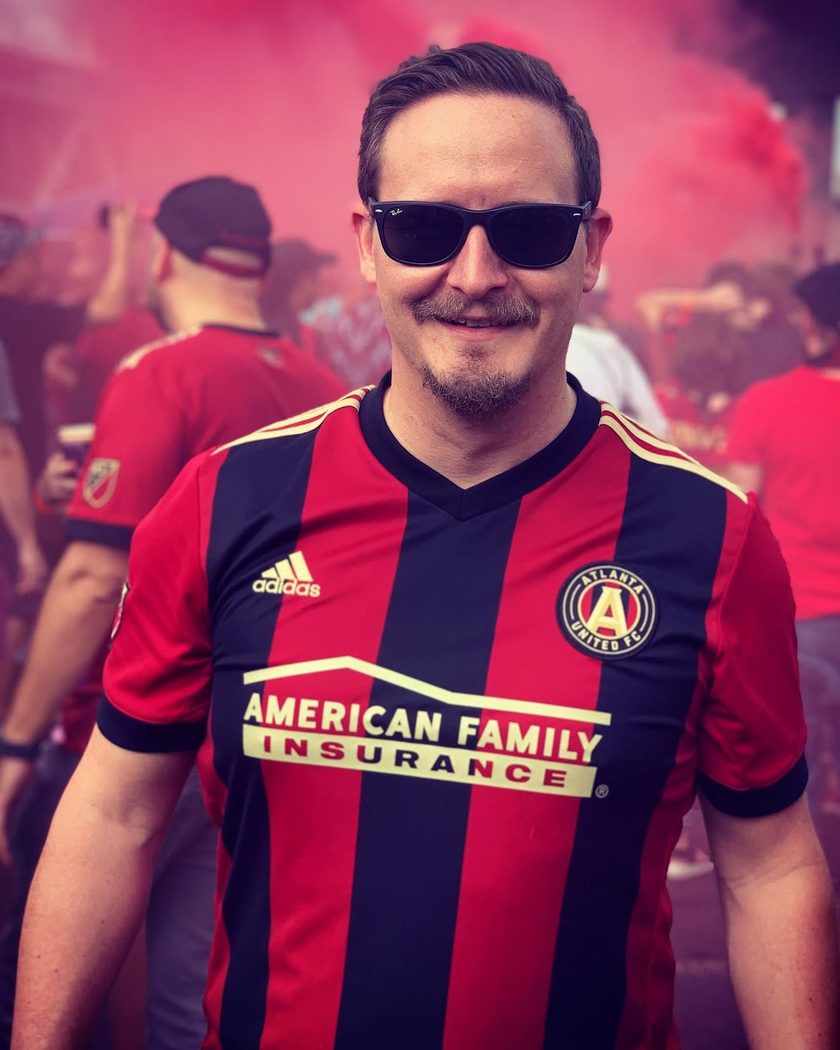 Dan in an Atlanta United jersey on matchday, red smoke behind him